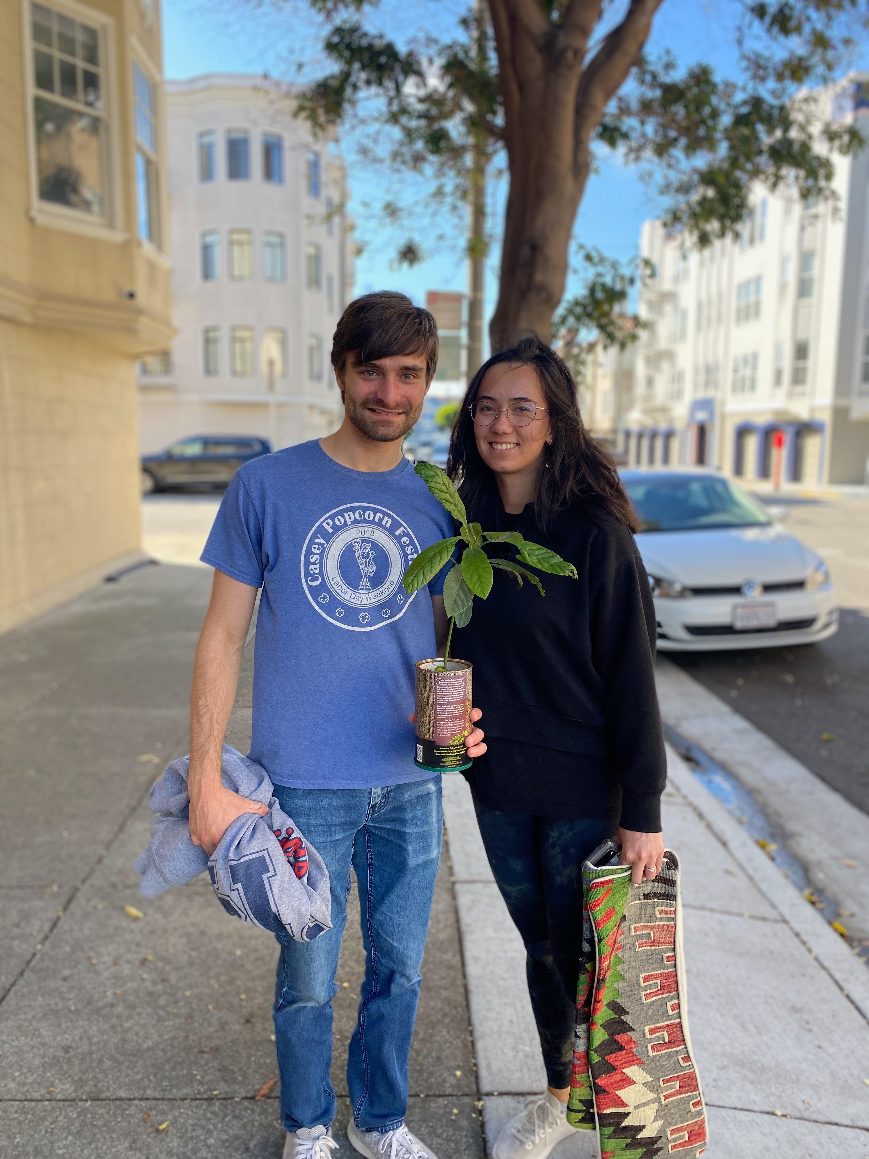 New plant parent smiling while holding a plant gifted by Reza Kaabi from Bank of Trees, ready to start their plant care journey.