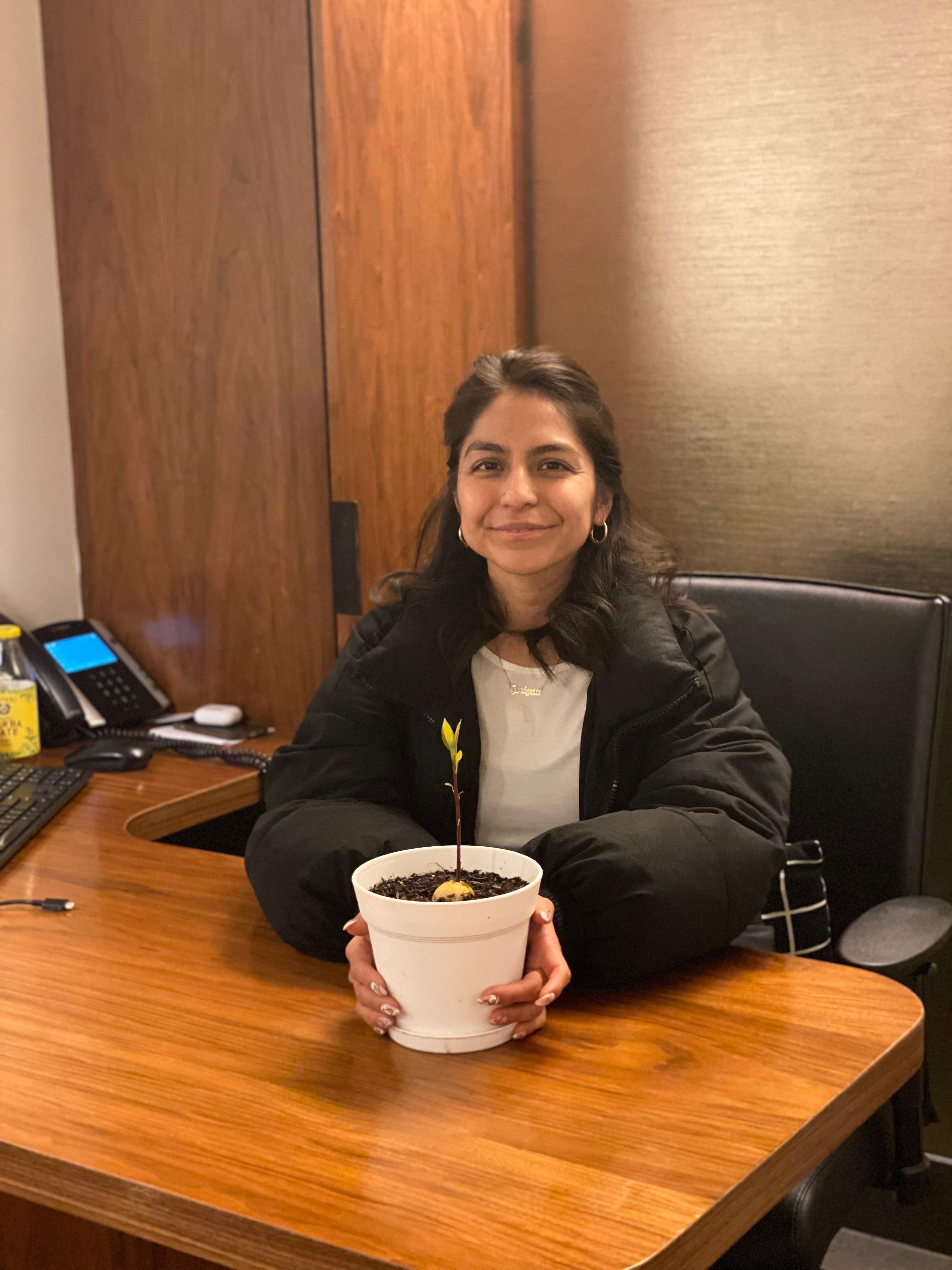 New plant parent smiling while holding a plant gifted by Reza Kaabi from Bank of Trees, ready to start their plant care journey.