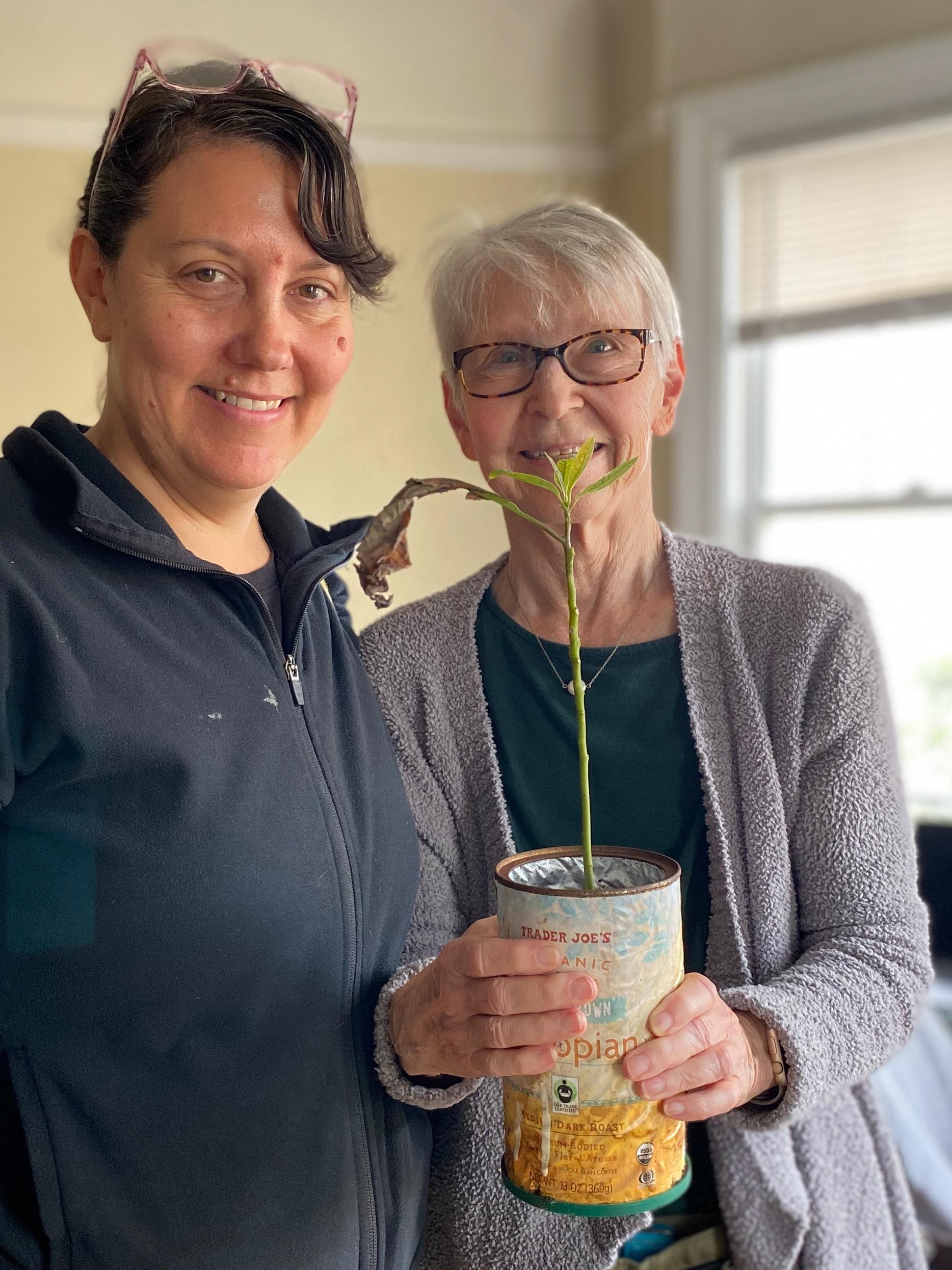 New plant parent smiling while holding a plant gifted by Reza Kaabi from Bank of Trees, ready to start their plant care journey.