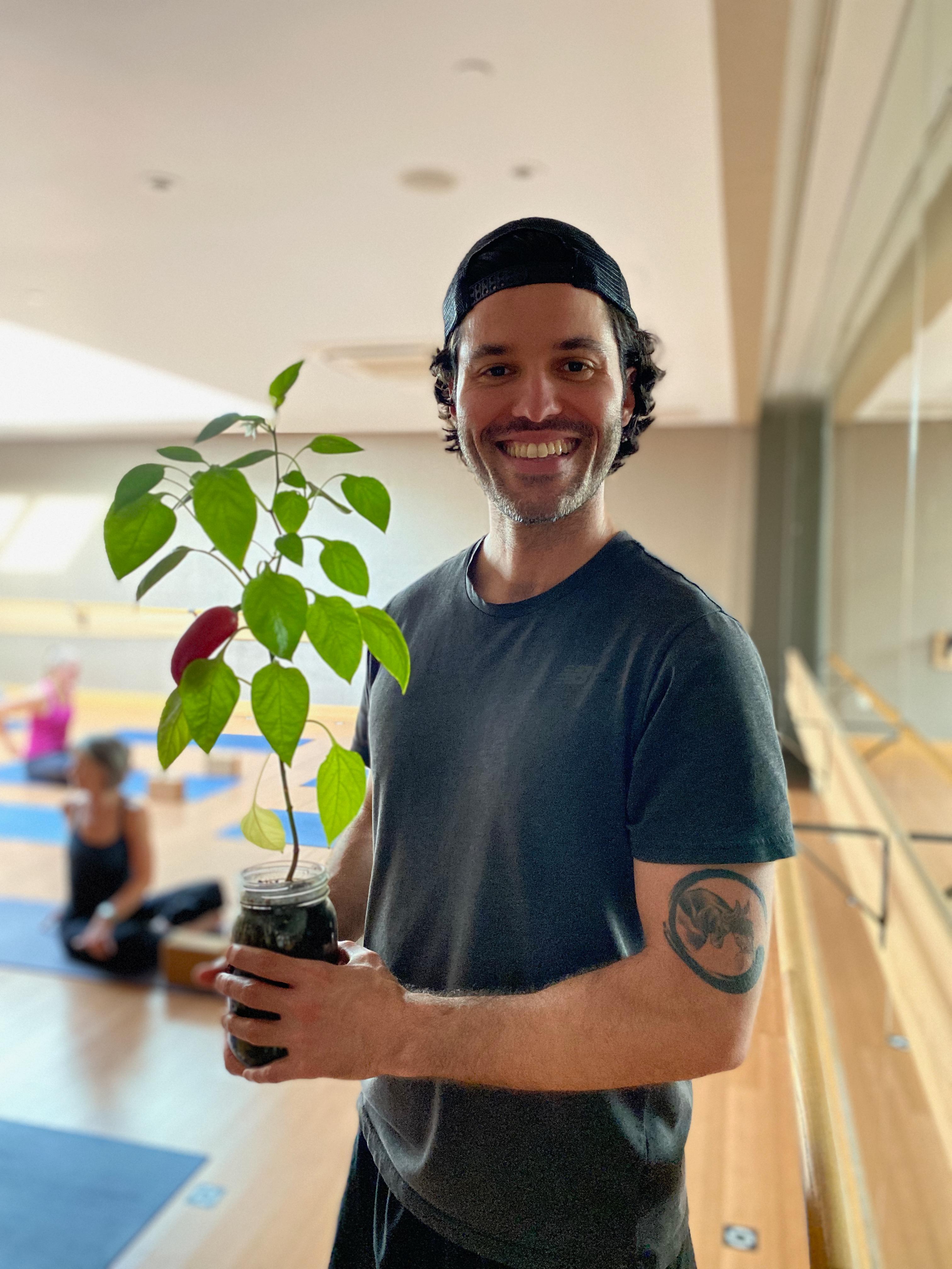 New plant parent smiling while holding a plant gifted by Reza Kaabi from Bank of Trees, ready to start their plant care journey.