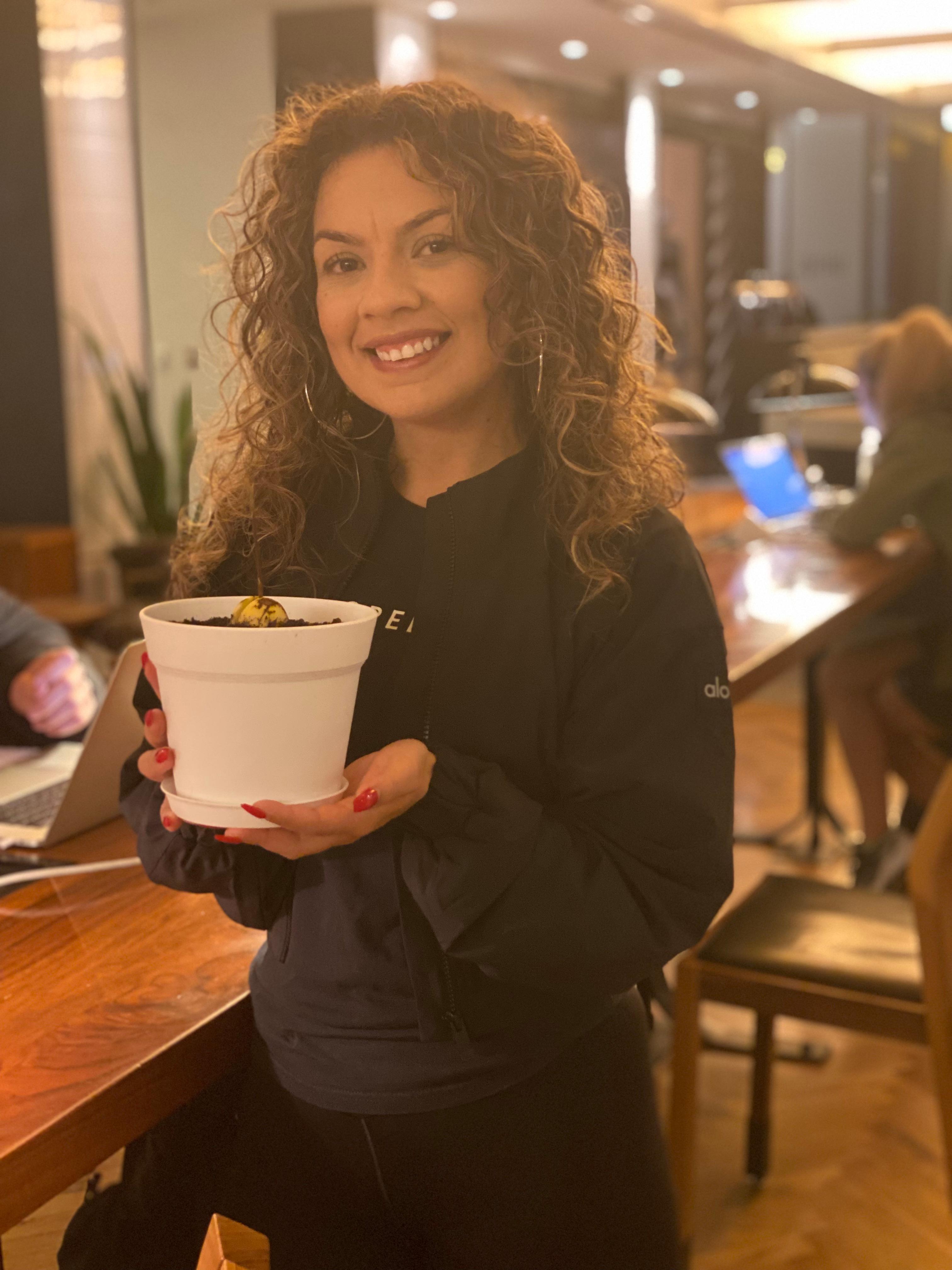 New plant parent smiling while holding a plant gifted by Reza Kaabi from Bank of Trees, ready to start their plant care journey.