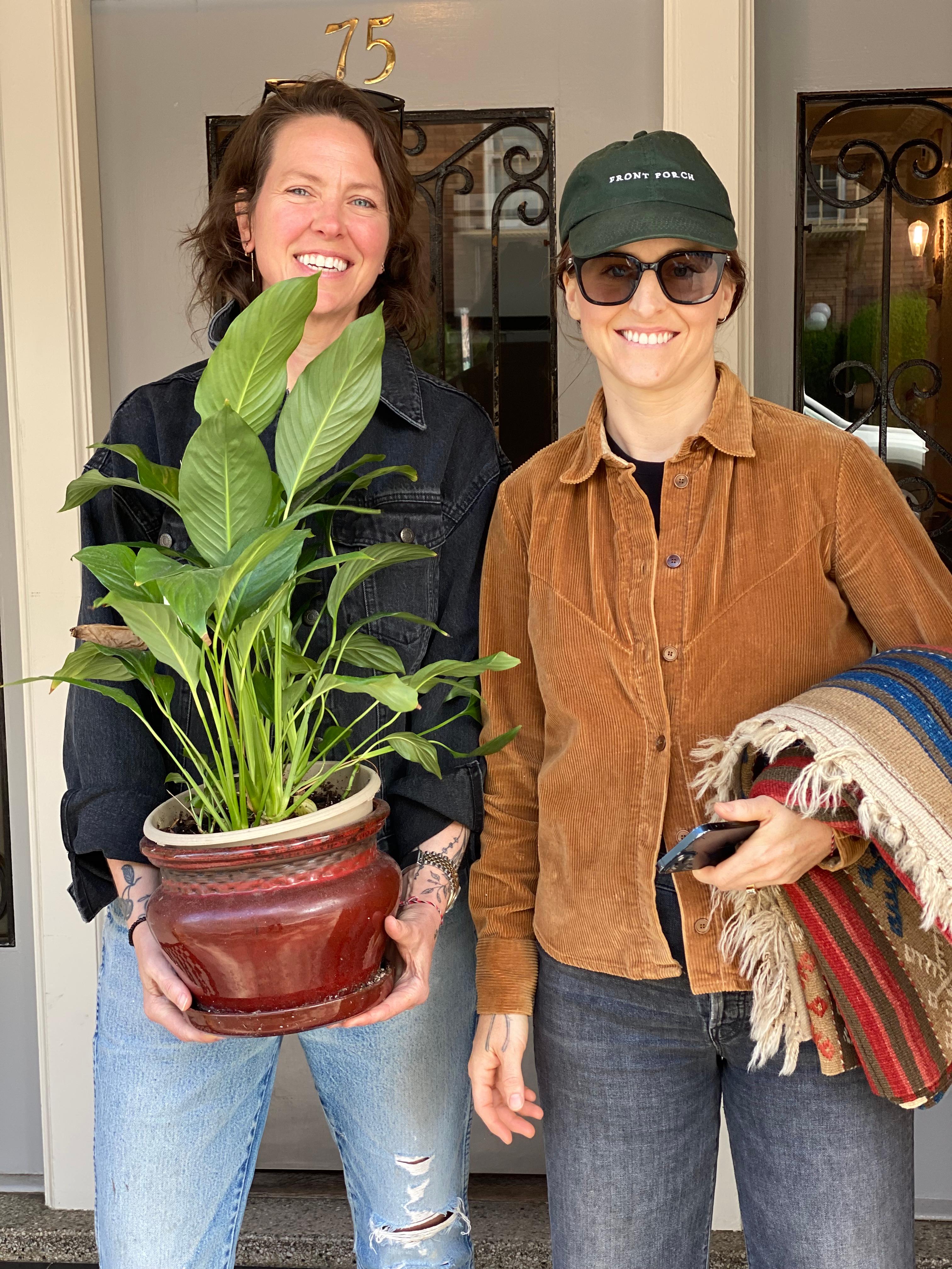 New plant parent smiling while holding a plant gifted by Reza Kaabi from Bank of Trees, ready to start their plant care journey.