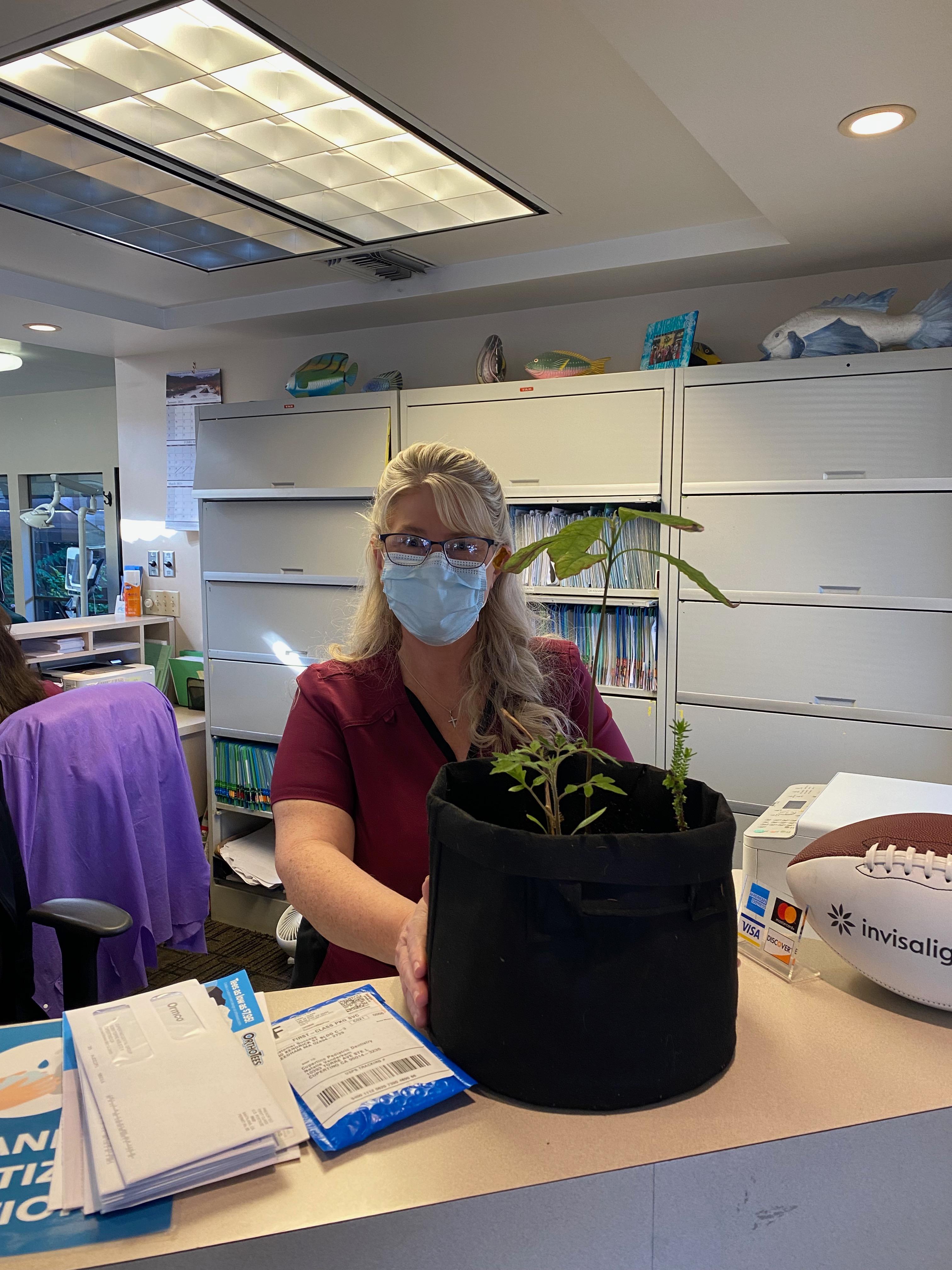 New plant parent smiling while holding a plant gifted by Reza Kaabi from Bank of Trees, ready to start their plant care journey.