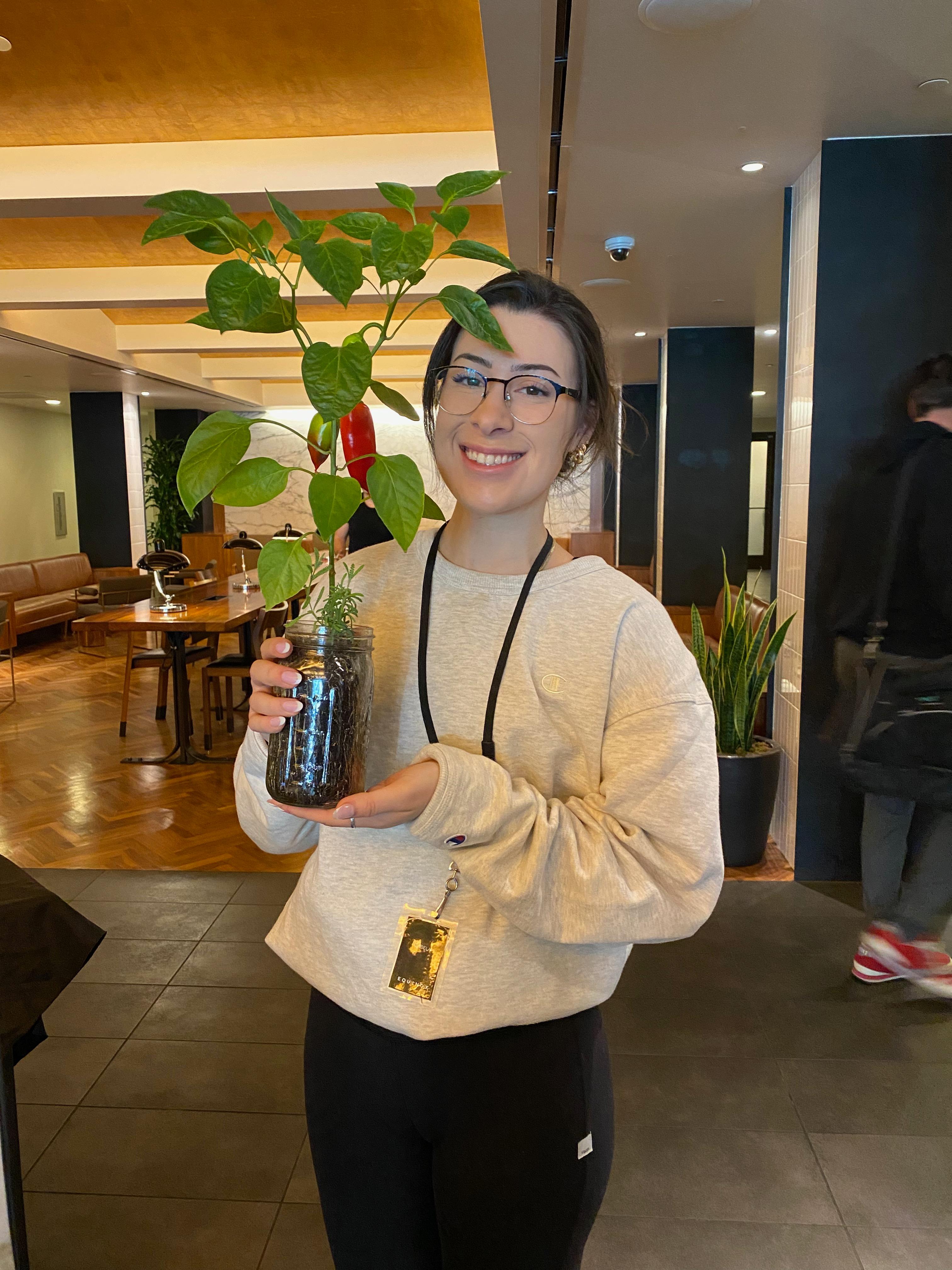 New plant parent smiling while holding a plant gifted by Reza Kaabi from Bank of Trees, ready to start their plant care journey.